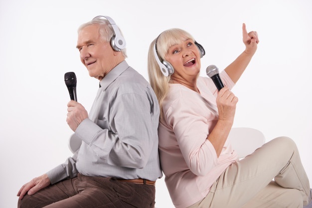 casal-de-idosos-em-fones-de-ouvido-esta-cantando-karaoke_99043-1615